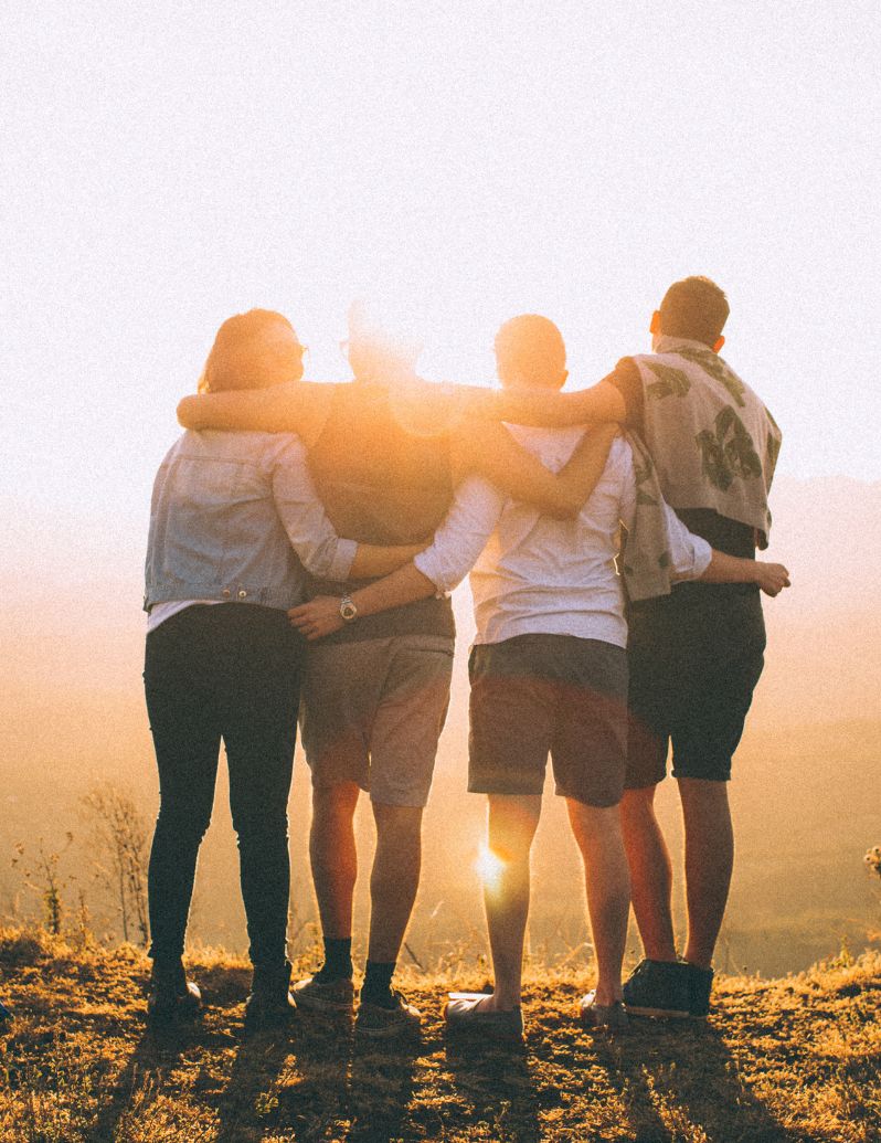 Friends providing emotional support at sunset - representing compassionate mental health therapy and supportive therapeutic relationships